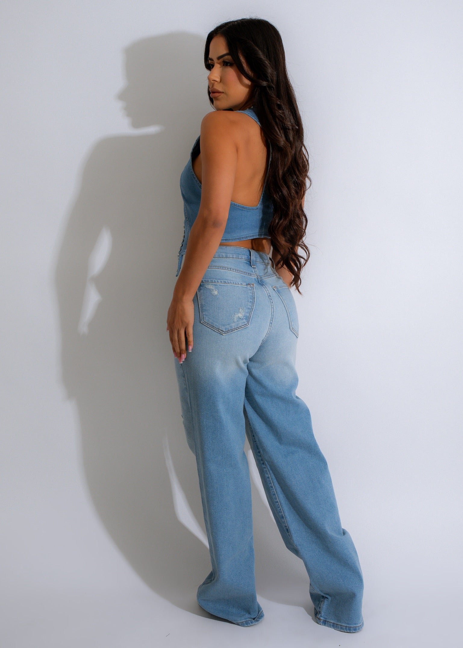 Fashionable women's vest top adorned with dazzling rhinestones on a denim background