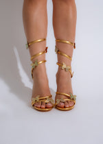 Shimmering gold high heels with rhinestone butterfly embellishments and ankle straps