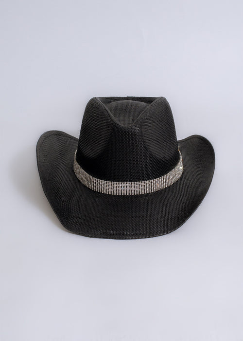 Black cowboy hat with rhinestone embellishments shining in the sunset