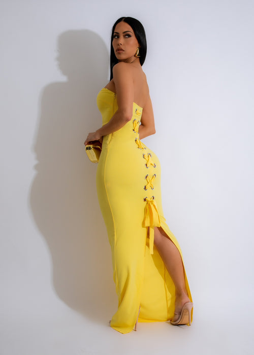 Alt text: A stunning yellow maxi dress with a flowing skirt and delicate lace detailing, perfect for a summer evening out