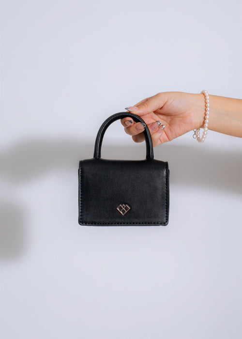 Black bow handbag with gold detailing, perfect for a glamorous Cannes Festival look