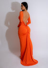 Smiling girl wearing a vibrant orange ruched maxi dress with a flowy silhouette and off-shoulder neckline