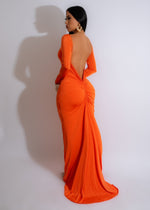 Smiling girl wearing a vibrant orange ruched maxi dress with a flowy silhouette and off-shoulder neckline