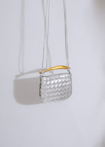 An elegant and eye-catching silver handbag adorned with sparkling gemstones and a chic metallic finish
###