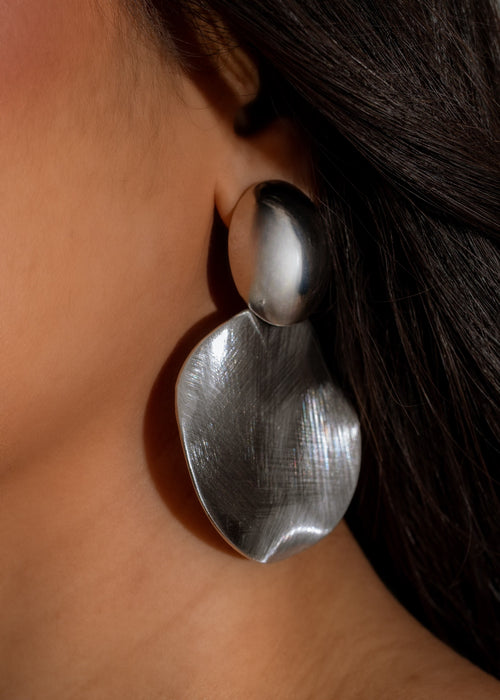 Shiny silver dangling earrings with intricate design, perfect for a glamorous look