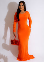  Confident model standing in a stunning orange maxi dress with ruched detailing and a bohemian vibe
