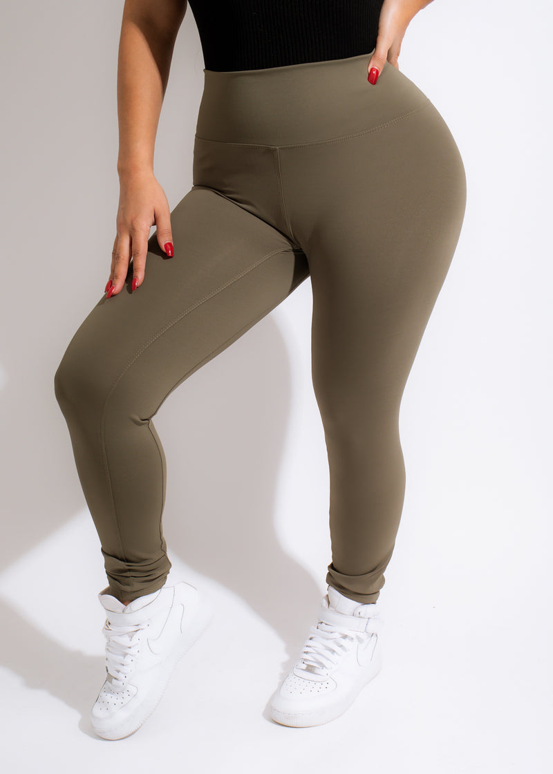 Close-up of a woman wearing high-waisted olive green Diva Leggings with a comfortable and stretchy fit for exercising or lounging