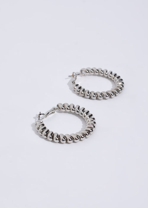 Pair of elegant silver earrings with intricate design and attention-grabbing appeal