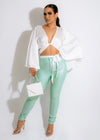 Green metallic pants with a high-waisted design and a slim fit