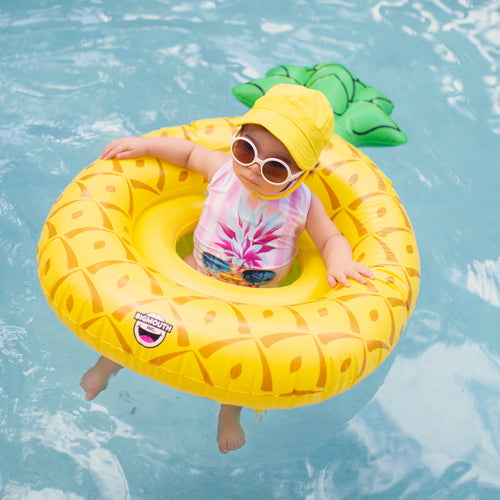 A colorful child swimsuit with a pineapple print and ruffled straps