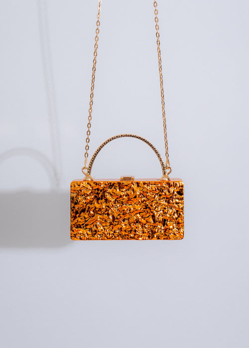  A close-up image of the My Distraction Handbag Orange, showcasing the intricate stitching and high-quality material of the product