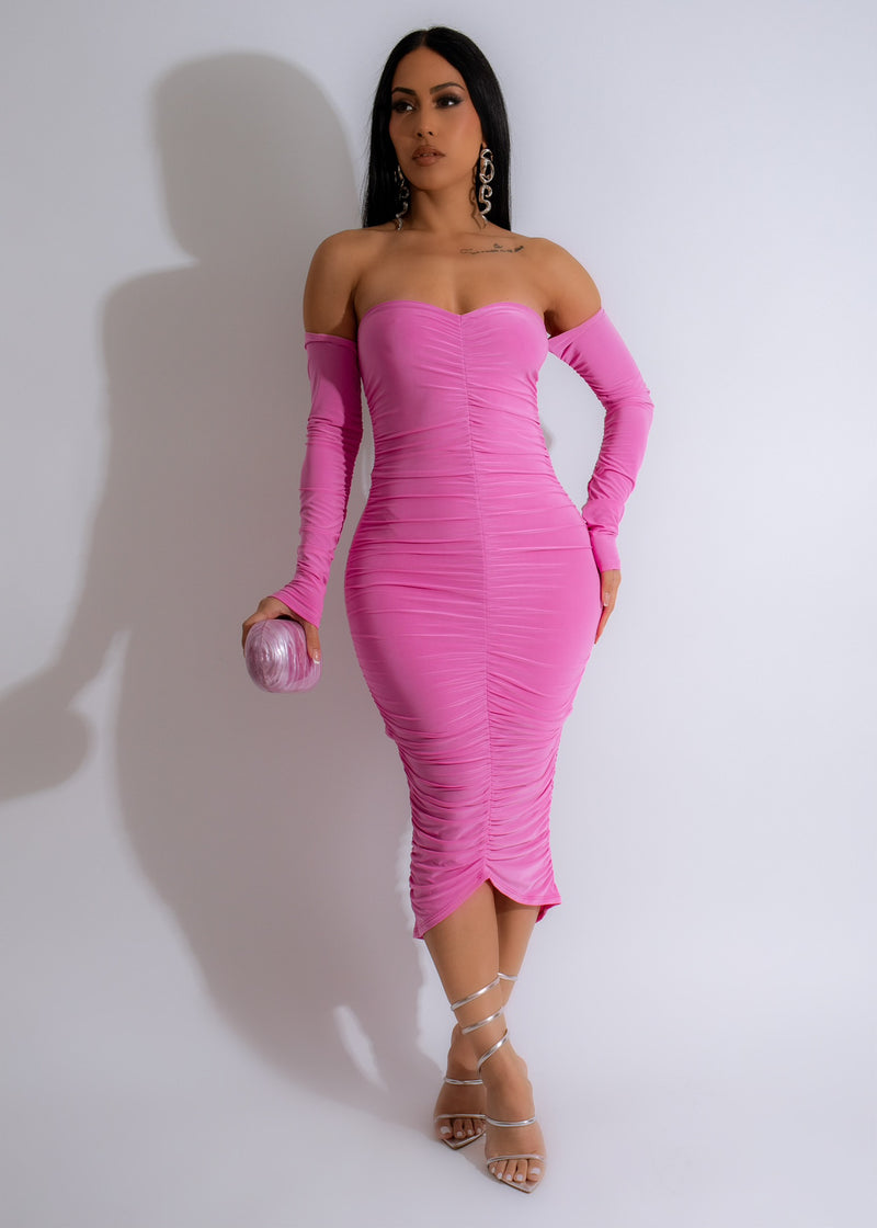 Vibrant Charm Ruched Midi Dress Pink on model with floral backdrop, showcasing its flattering ruched design and elegant pink color
