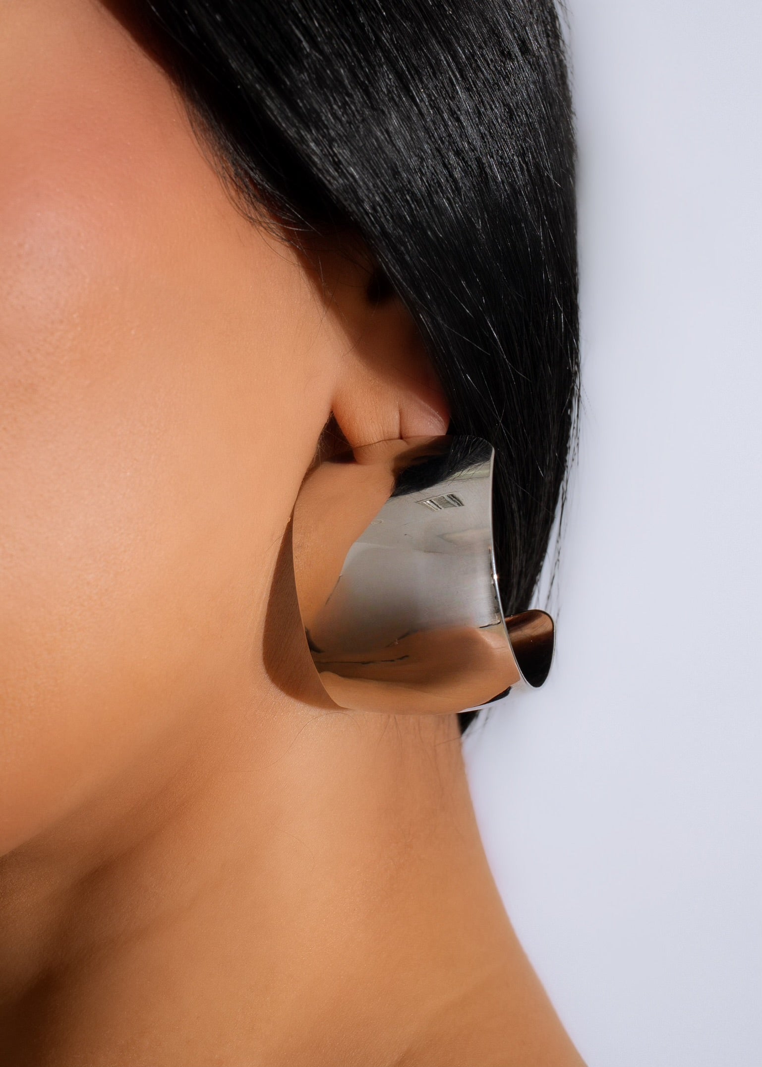 Shiny silver earrings with intricate design, perfect for a glamorous after party look