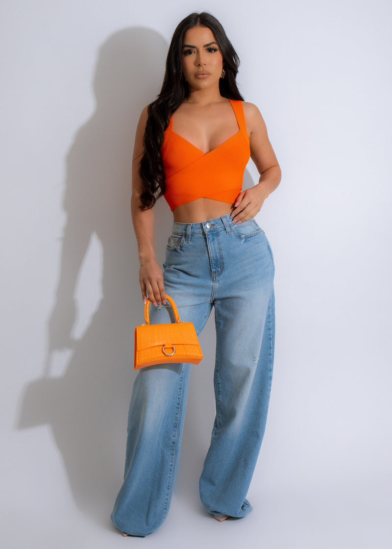 Close-up of a woman wearing a vibrant orange ribbed crop top with a textured design, perfect for a stylish and bold statement look