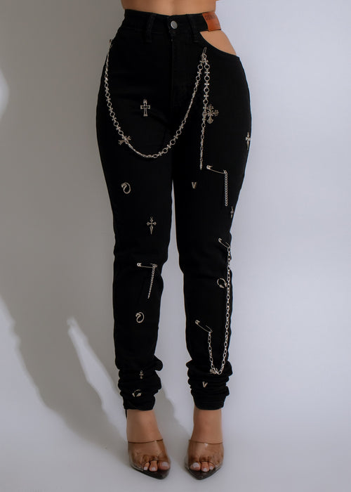 Close-up of black jeans with metal chain accents and distressed texture