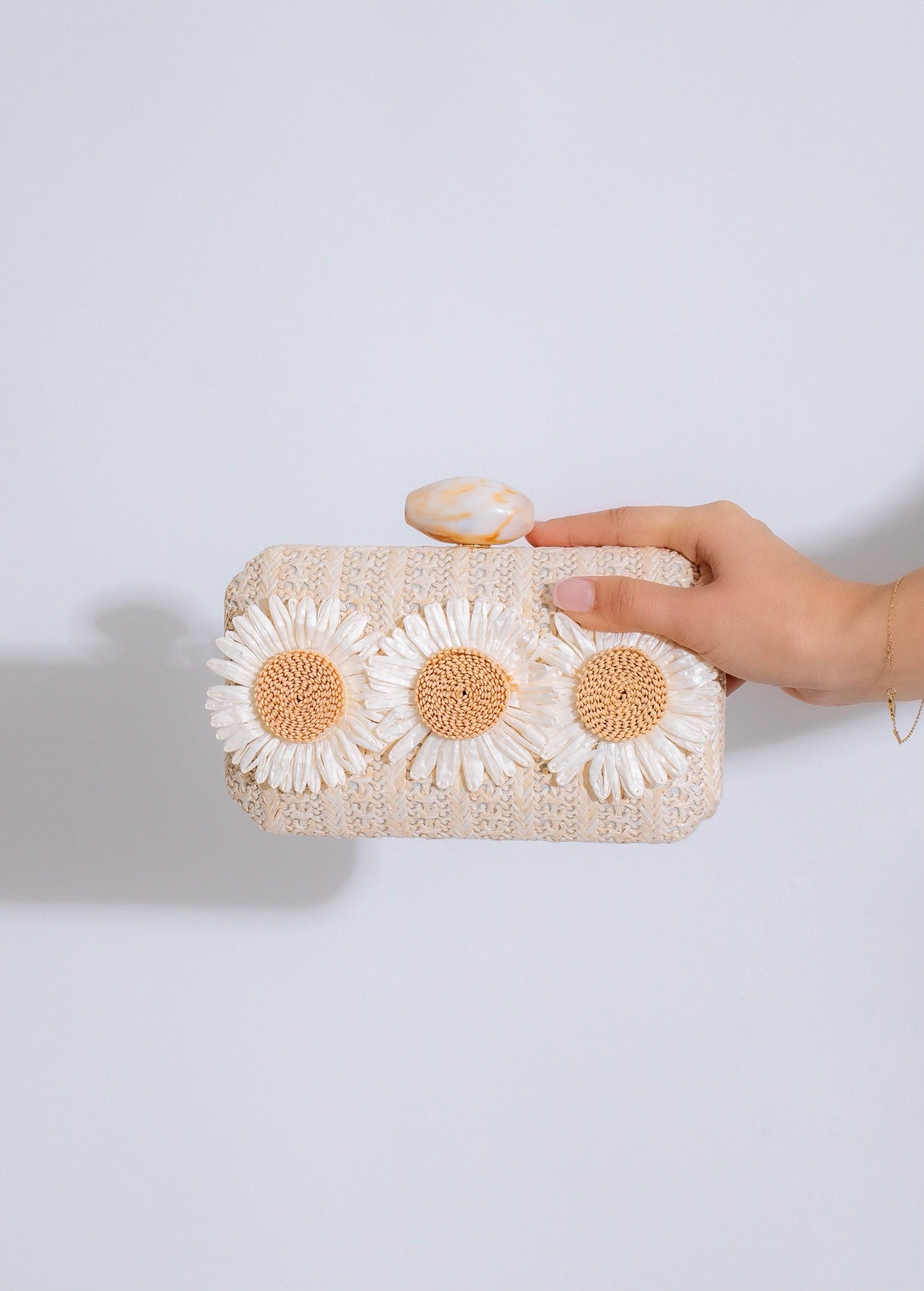 Beautiful nude Daisy Love Clutch with delicate floral accents and gold hardware