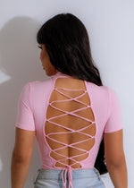 A close-up image of a pink For You Bodysuit with delicate lace detailing
