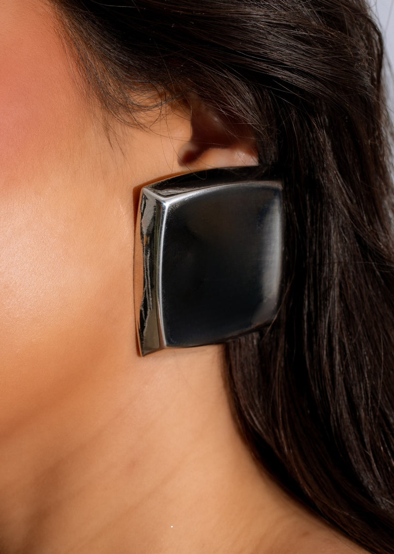 Shiny silver earring with midnight blue gemstone and sparkling accents