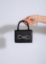 Black bow handbag with intricate detailing, perfect for Cannes Festival