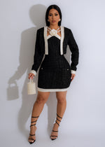 Front view of a black tweed mini dress with pearl details