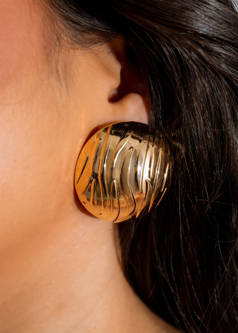 Shimmering gold hoop earring with intricate design, a must-have accessory