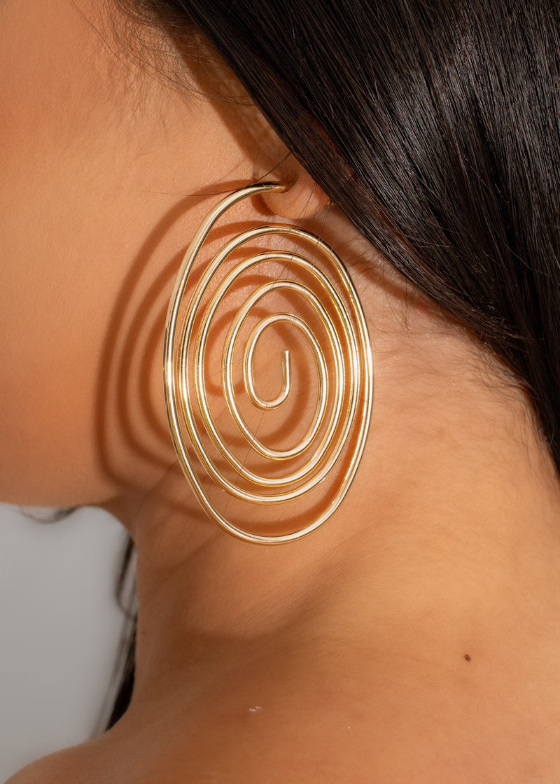 A close-up image of the Spontaneous Earrings Gold, featuring intricate gold details and a unique, eye-catching design