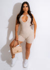  Woman wearing nude ribbed romper with a cinched waist and flared shorts