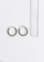 Shiny silver earrings with intricate design and attention-grabbing details