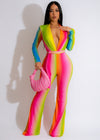 Dreaming In Colors Jumpsuit in vibrant shades of blue, green, and pink, with a flattering wrap-style top and wide-leg pants