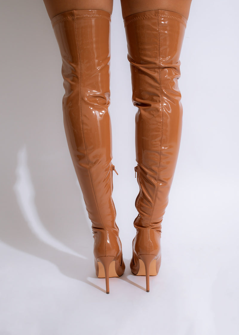 The Savage Latex Knee High Boots in Brown are a bold and daring addition to any wardrobe, perfect for those who want to stand out in a crowd