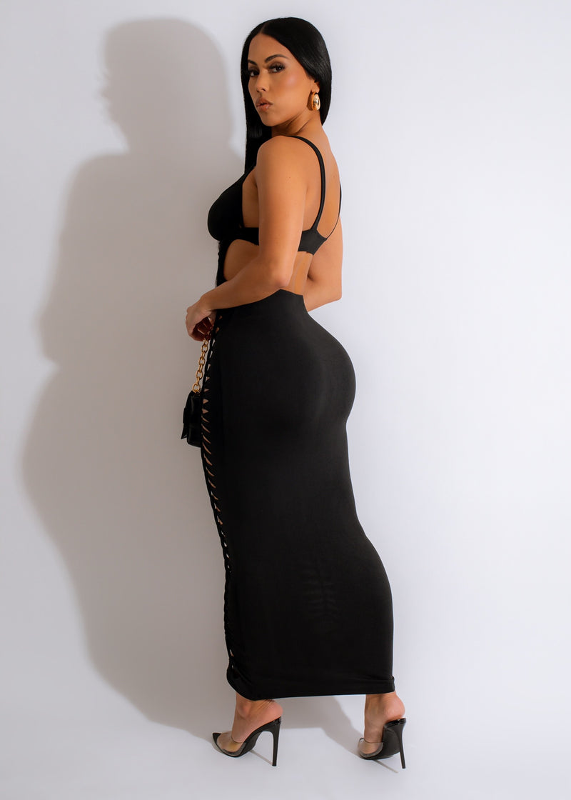  Side view of a woman wearing the Meet You There Midi Dress in Black, featuring a fitted bodice and flared skirt for a flattering silhouette