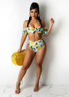 When Life Gives You Lemons Bikini, a yellow two-piece swimsuit with fruity print and ruffle details, perfect for summer beach days and poolside lounging